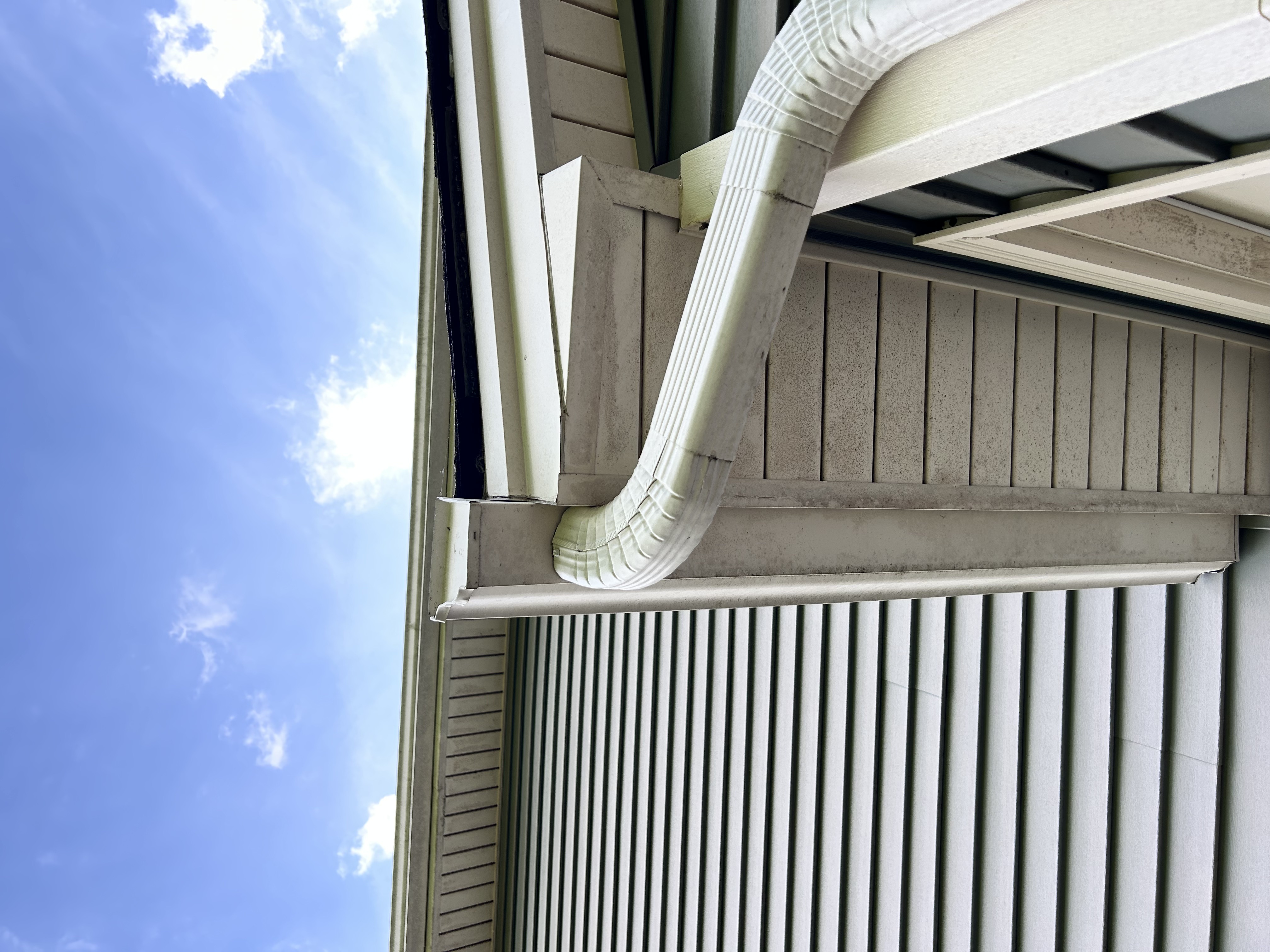 Water overflowing from a clogged gutter causing foundation erosion